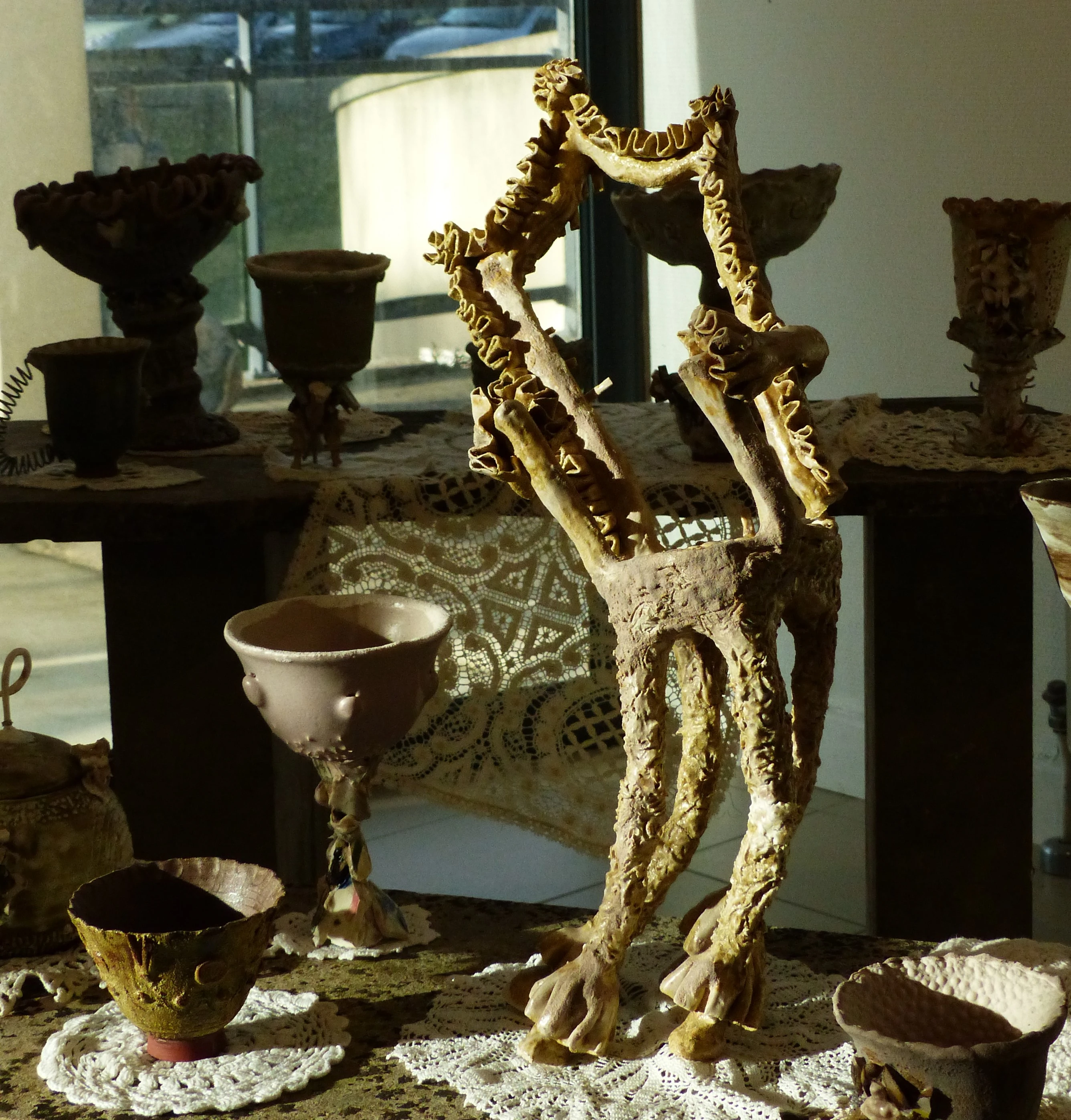 Sculpture d'une chaise qui est habillé de froufrous, qui semble se pencher sur un coté comme une révérence