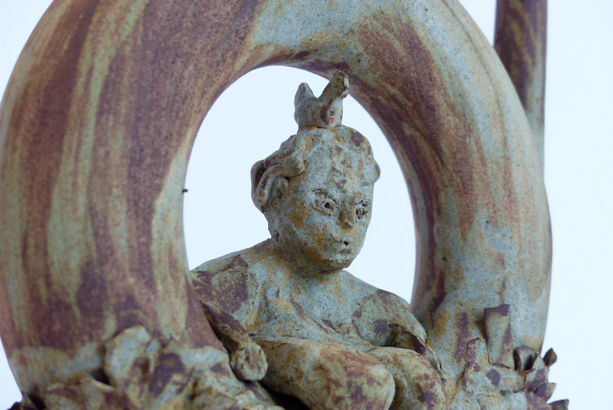 Gourde tournée, ornementée avec une petite dame assise avce une poule sur la tête