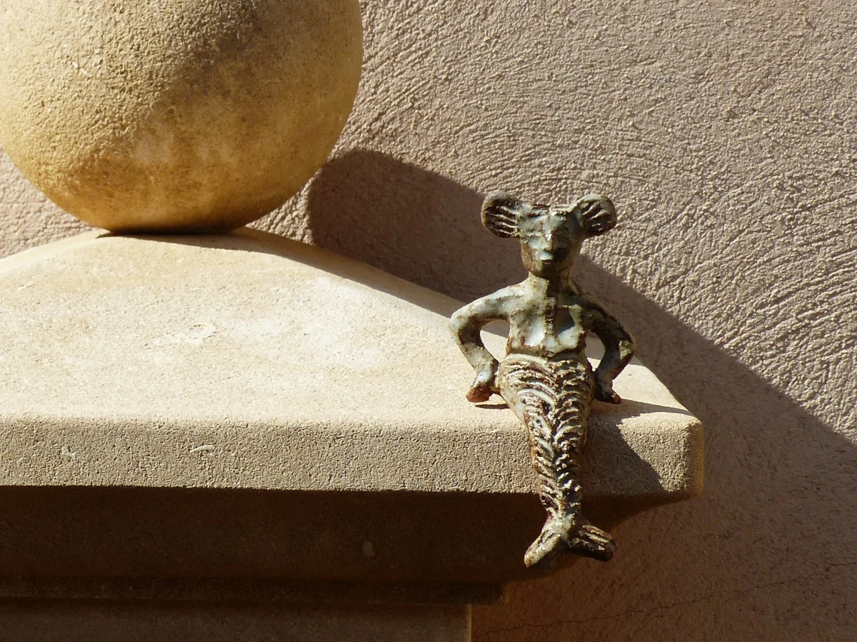 une sculpture de sirene posée sur la fontaine