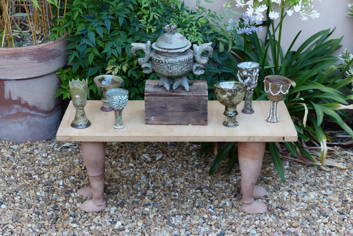 Table sur deux socles en forme de jambes, des pièces sont posés sur la table
